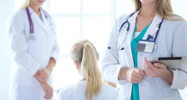 Portrait of three confident female doctors standing with arms crossed at the medical office