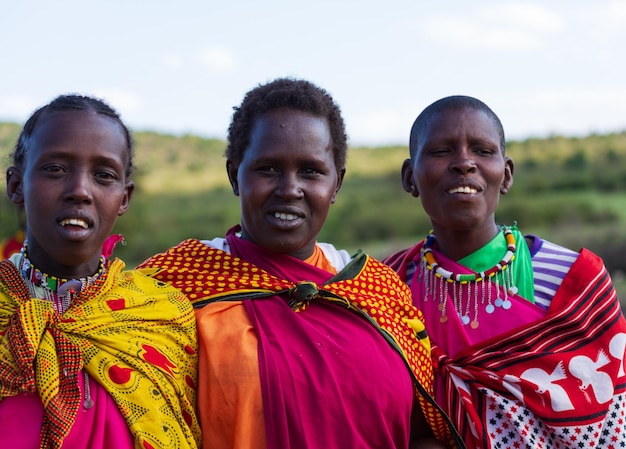 A portrait of three Masai Mara women in their colourful national clothes. Masai Mara, Kenya