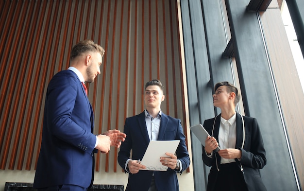 Portrait of three partners discussing ideas at meeting.