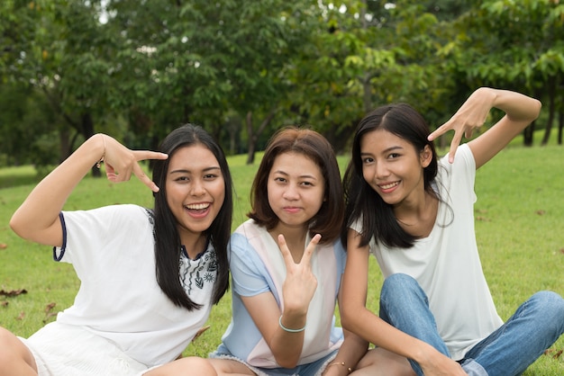 Портрет трех молодых красивых азиатских девочек-подростков, отдыхающих в парке на открытом воздухе