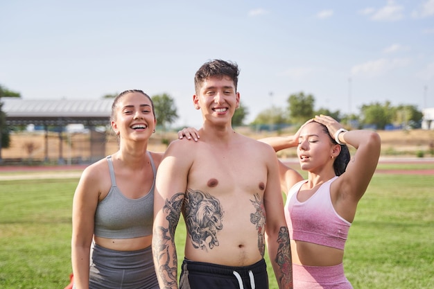 Portrait of three young sportsmen posing three friends having fun while playing sports outdoors