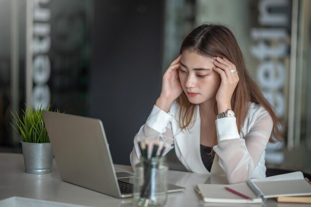 Foto ritratto di donna asiatica stanca di affari che lavora nell'ufficio