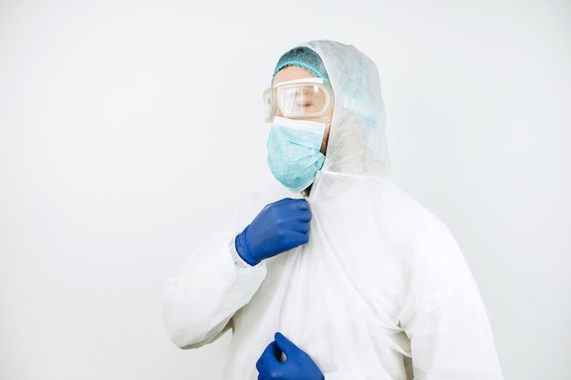 Портрет утомленного доктора после смещения в больнице. Доктор в защитной одежде - очки, маска, перчатки. Врач лечит пациентов с коронавирусом. Covid-2019