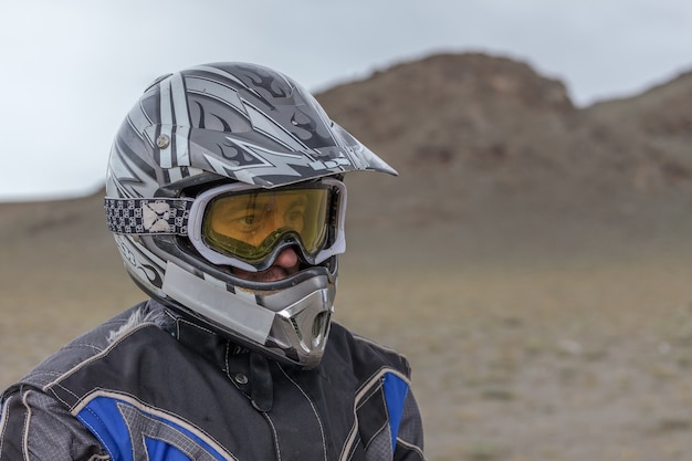 Portrait of a tired motorcyclist on the background of Altai mountains