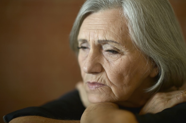 Photo portrait of tired senior woman at home, close up