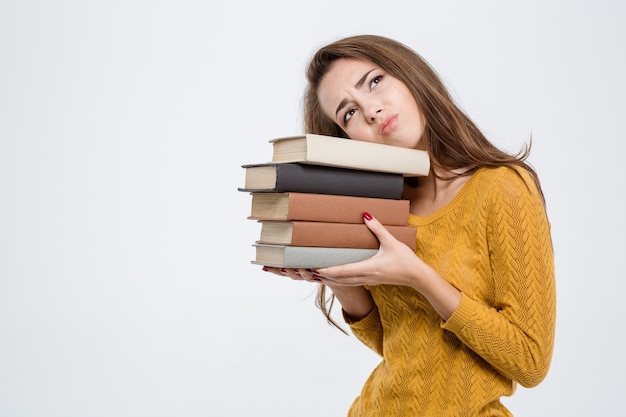 Portrait of a tired woman holding books isolated on a white background