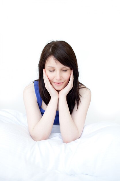 Portrait of a tired woman sitting on her bed