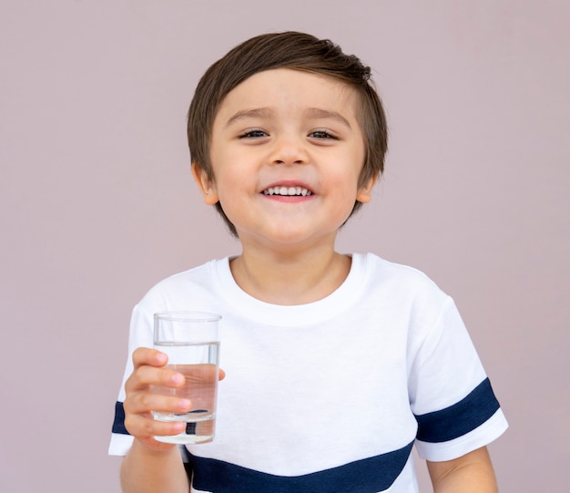 Portrait of toddler boy drinking glass of water