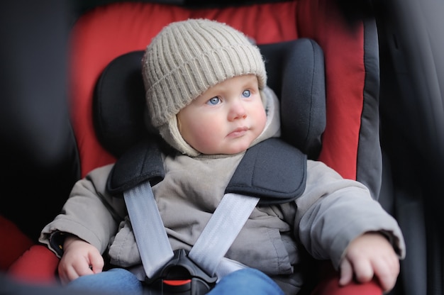 Portrait of toddler boy sitting in car seat