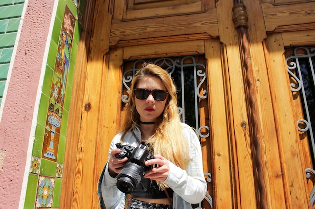 카메라를 찾고 선글라스에 관광 여자의 초상화