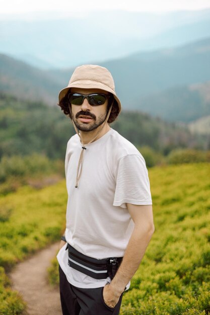 Foto un ritratto di un viaggiatore vestito con abiti leggeri che viaggia lungo le pendici dei carpazi e posa per una foto