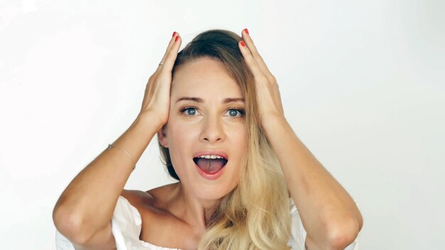 Portrait troubled woman clutching at head and looking into camera