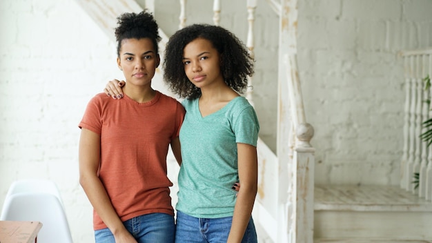 Portrait of two beautiful african american girlslooking into camera indoors