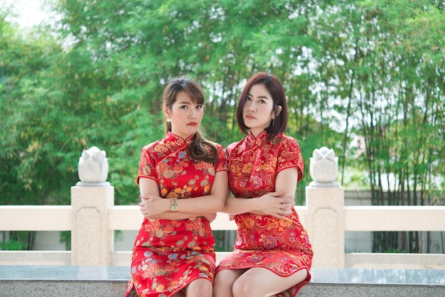 チャイナドレスの2人の美しいアジアの女性の肖像画タイの人々幸せな中国の旧正月のコンセプト