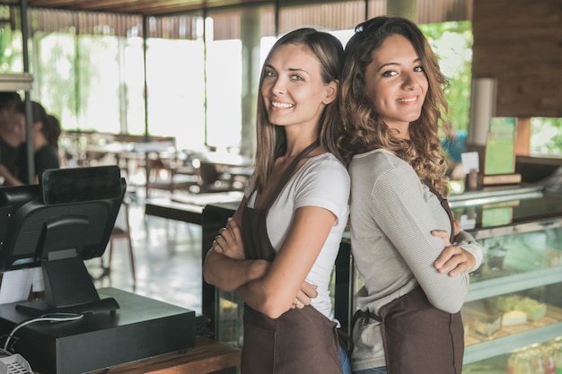 Portrait of two beautiful female waitress smiling to camera
