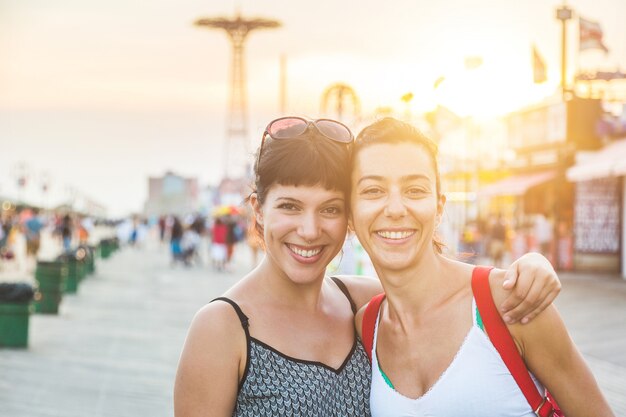 Un ritratto di due belle donne in coney island al tramonto