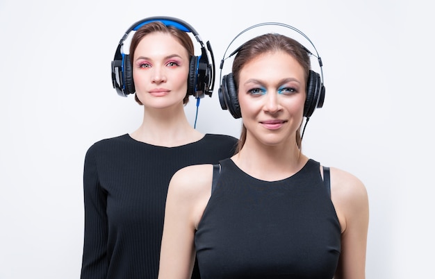Portrait of two beautiful women with headsets. Technical support concept. Mixed media