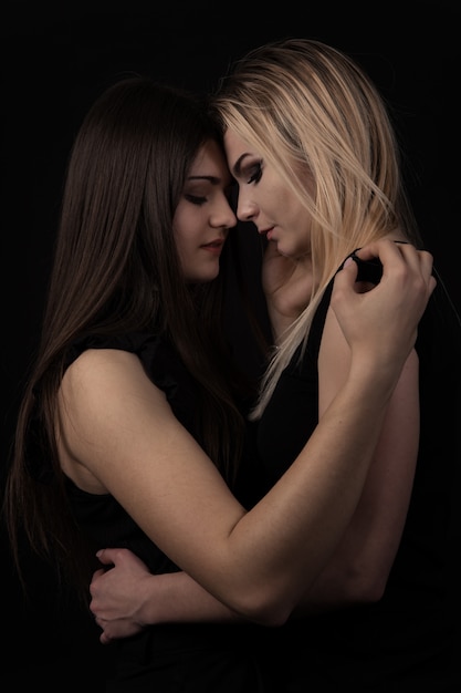 Portrait of two beautiful young women on black background
