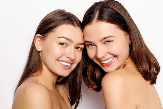 Portrait of two beautiful young women on grey background