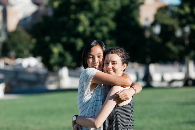 Portrait of two best friends hugging each other in the park