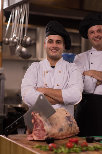 Portrait of two chefs standing together in commercial kitchen at restaurant