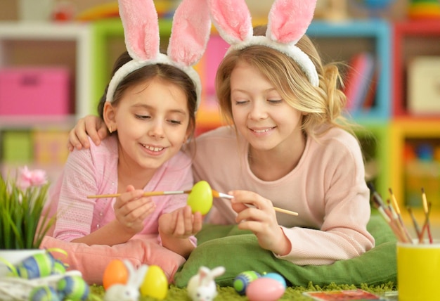 Portrait of two cute girls painted Easter eggs