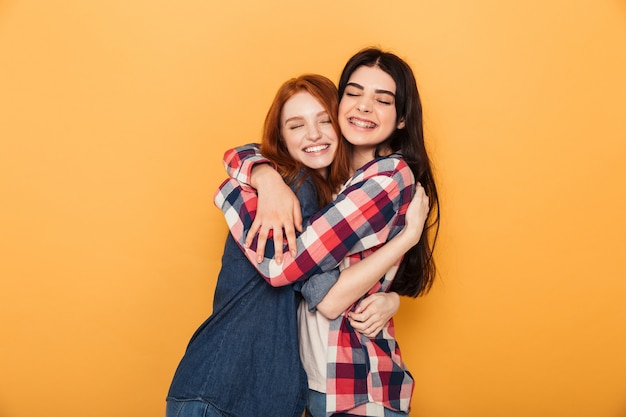 Portrait of two delighted young women hugging