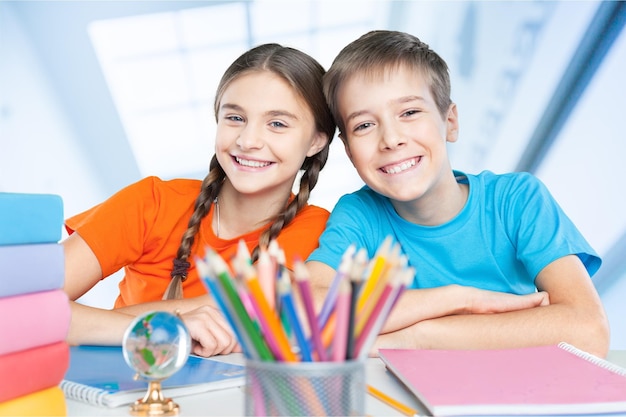 背景に男子生徒と職場でカメラを見ている2人の勤勉な女の子の肖像画