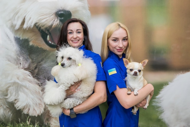 Portrait of two female groomers with dogs in a dog salon against