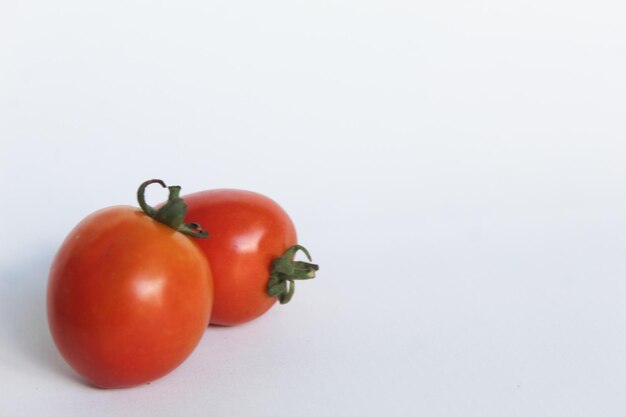 Foto ritratto di due pomodori freschi su uno sfondo bianco