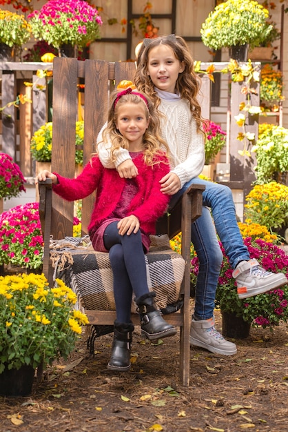 портрет двух девочек-сестер осенью возле дома