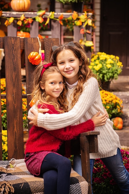 portrait of two girls sisters in autumn near the house