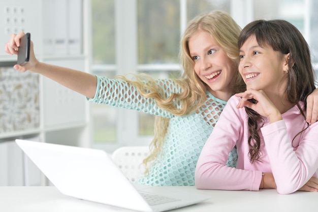 Portrait of two girls with phone and laptop