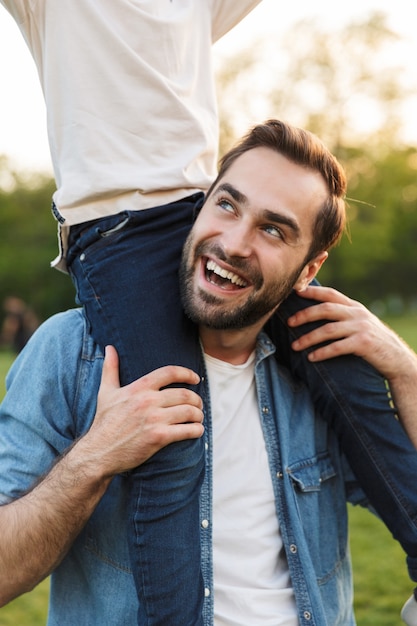 Portrait of two happy brothers spending fun time at the park, piggyback ride