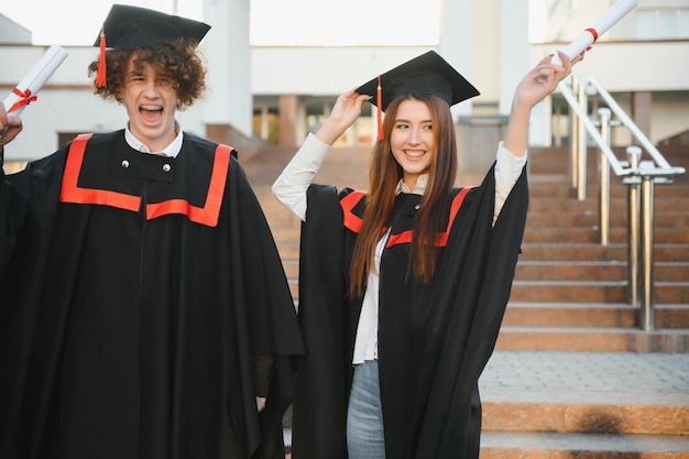 Portrait of two happy graduating students