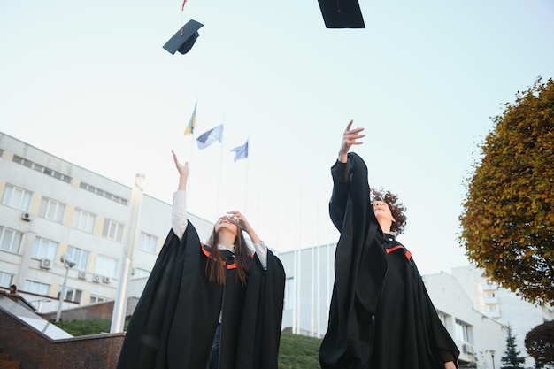 Portrait of two happy graduating students