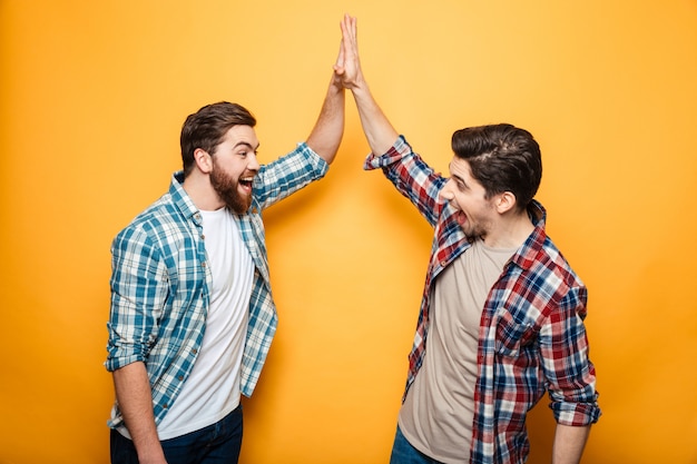 Portrait of a two happy young men giving high five