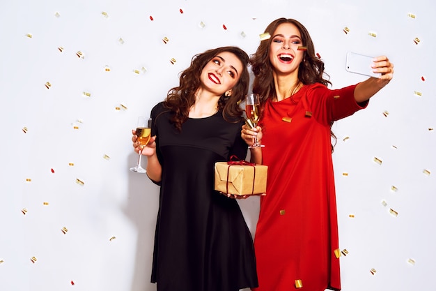 Portrait of two happy young women who make selfie.