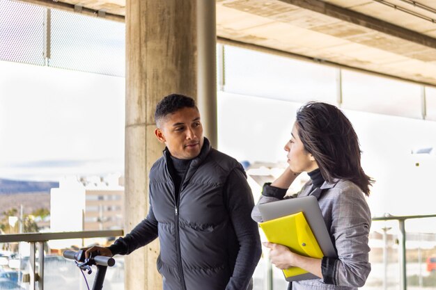 Portrait of two latino students talking on the street on their way to college