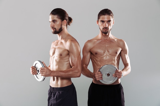 Portrait of a two muscular shirtless twin brothers