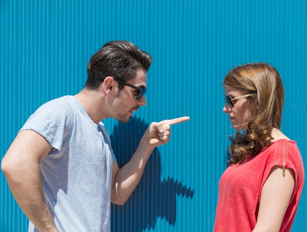 Portrait of two people, man and woman , woman to man pointing fingers, blaming her for the problem. Difficulties in marriage concept . Negative emotions