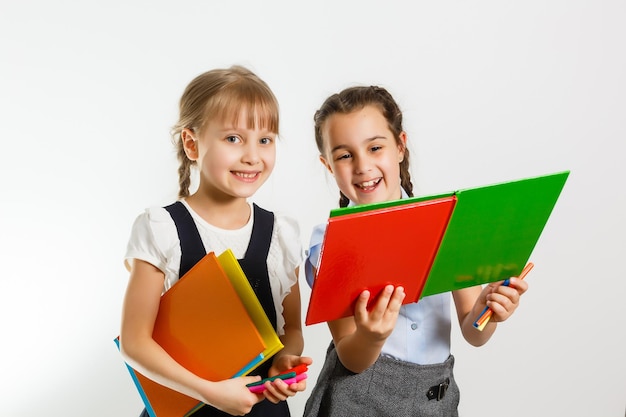 Portrait of two people nice cute lovely charming dreamy attractive cheerful pre-teen girls siblings showing aside ad promotion copy space isolated background