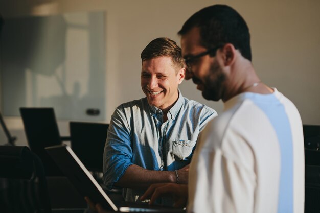 Portrait of two professional male programmers working on computer in diverse offices Modern IT technologies development of artificial intelligence programs applications and video games concept