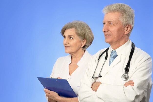 Portrait of two senior doctors on a blue background