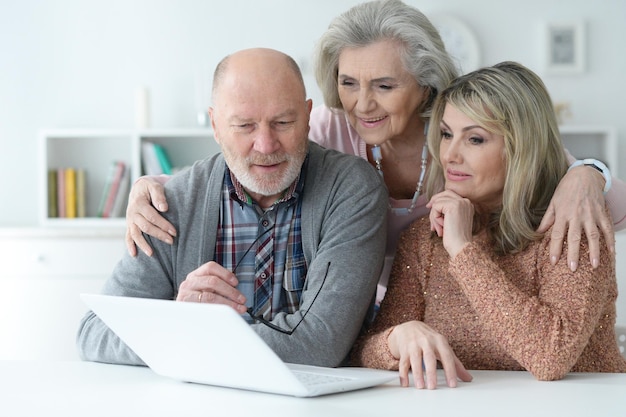 Photo portrait of two senior women and man using laptop