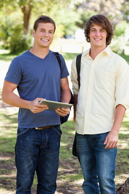 Photo portrait of two smiling male students with a touch pad