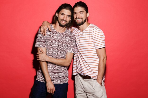 Портрет двух улыбающихся братьев-близнецов стоя