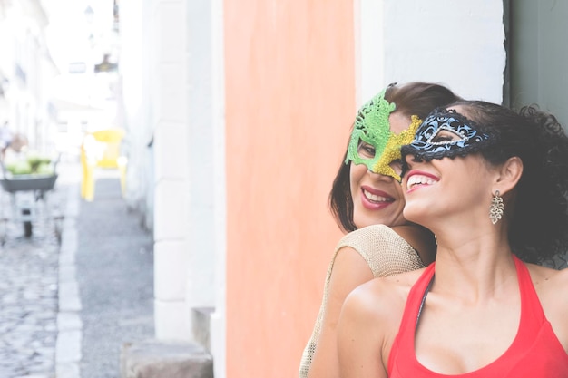 Photo portrait of two women wearing venice carnival mask