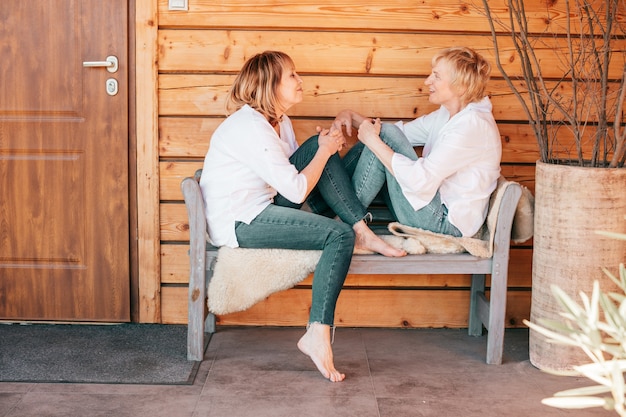 Photo portrait of two women on a wooden background sitting opposite each other spending free time together