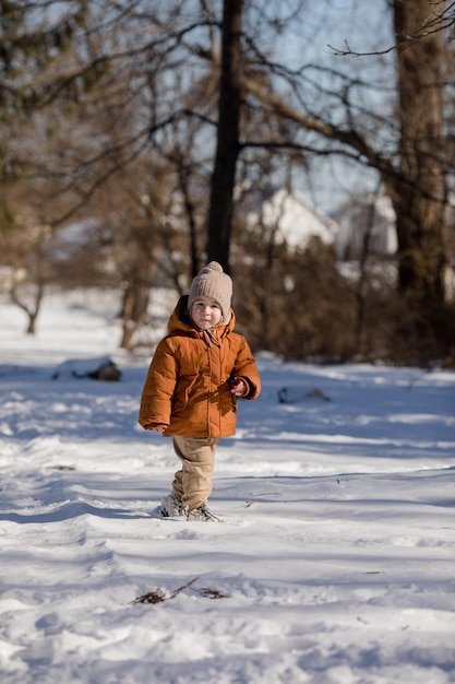 冬の新鮮な雪の中に立って屋外で遊んでいる2歳の男の子の肖像画